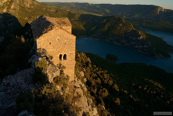 Ermita románica de Santa Quiteria y San Bonifacio del siglo XI iluminada por las últimas luces del atardecer. Destaca la ventana geminada en su fachada Oeste y el tejado de losa.